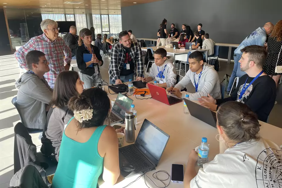 Un equipo del Cienciathon 2024 trabajando alrededor de una mesa con portátiles