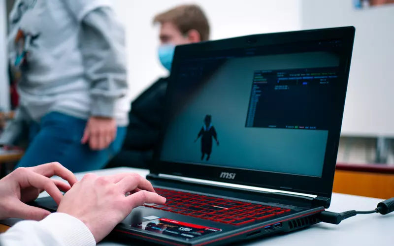 Participante mostrando su videojuego en un portátil durante la UAGames DevCon de 2022